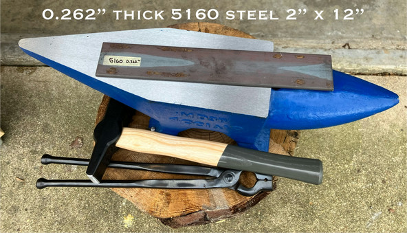 Bar stock sitting on anvil next to hammer and tongs